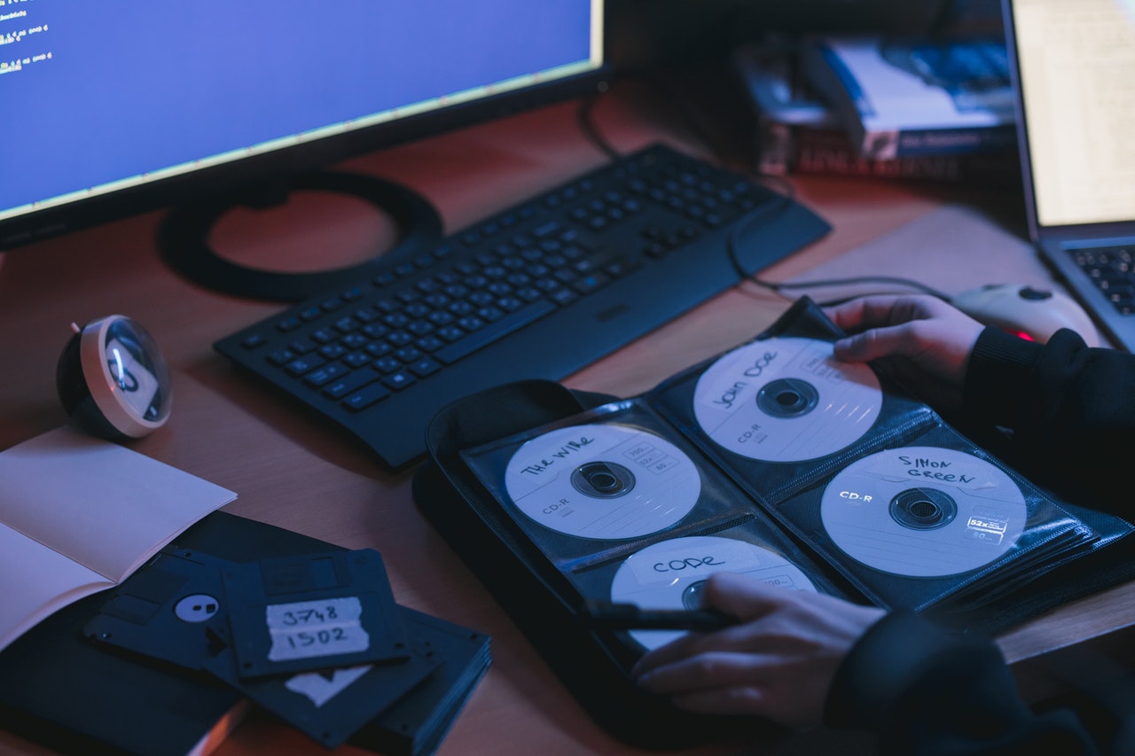 A person sorting through a collection of pirated dvds or cds