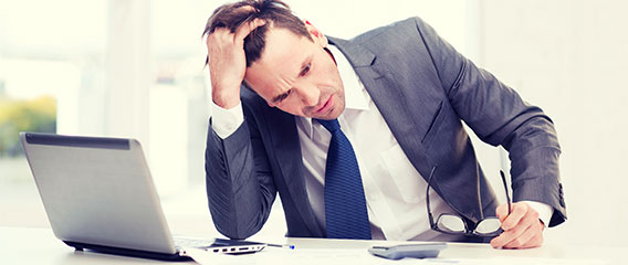 Frustrated office employee on laptop computer that has web filtering software.