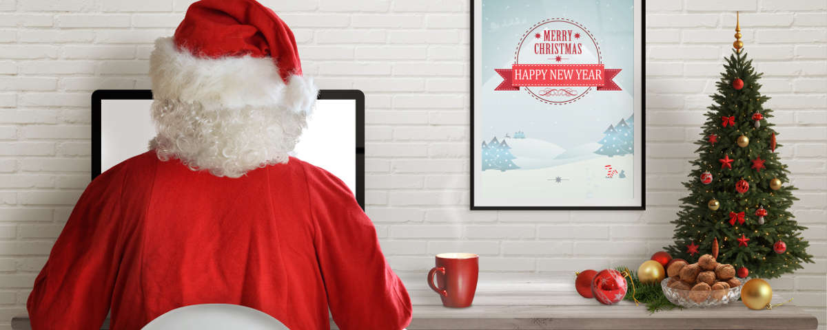 Santa Clause on a desktop computer reviewing employee productivity reports.