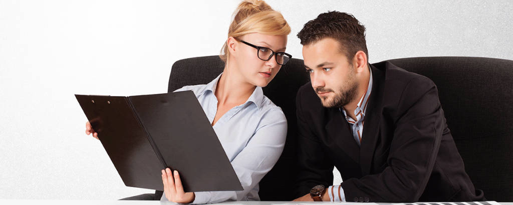Female employer showing her male employee a productivity report.