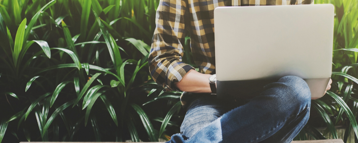 Remote worker on a laptop sitting outside