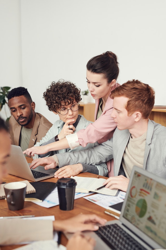 block-distracting-websites 4 office employees reviewing reports on their laptops