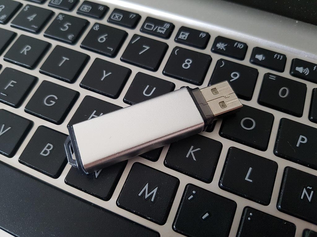 A photo of a USB thumb drive on top of a laptop keyboard