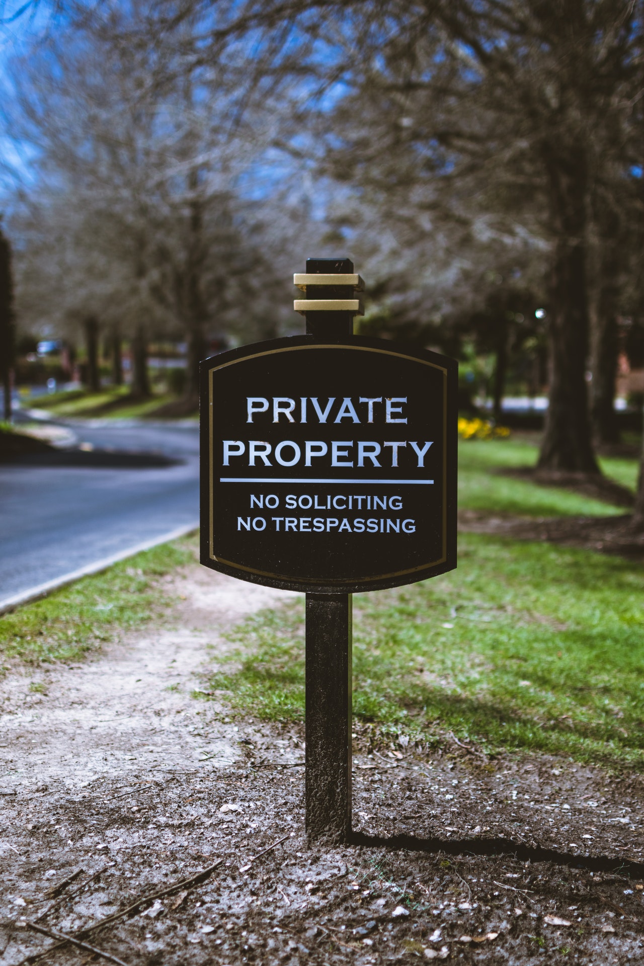A sign in front of someone's yard that says "Private Property: No soliciting or tresspassing"