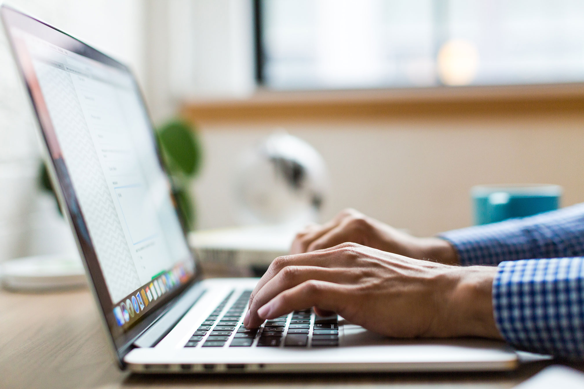 man using the internet and typing on a laptop