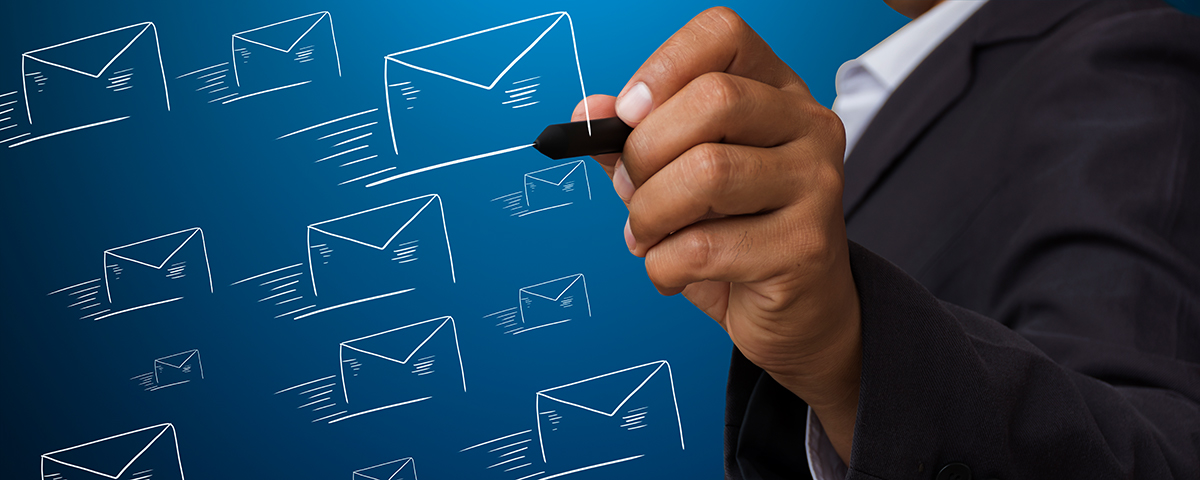 A man's hand draws outlines of email envelopes. Blue background