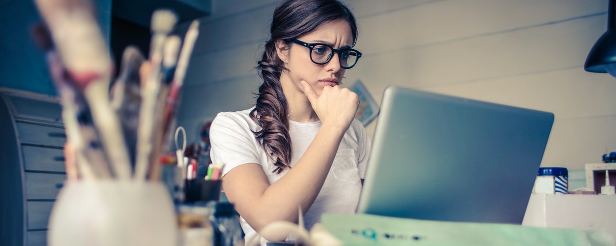 Woman deep in thought while viewing laptop