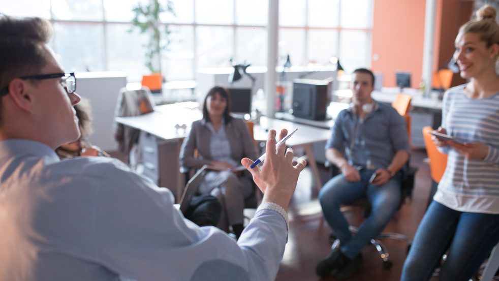 group of employees listening to a speaker