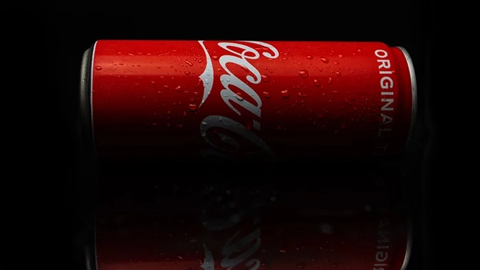 Dramatically lit photo of a red Coca-Cola can engulfed in shadows